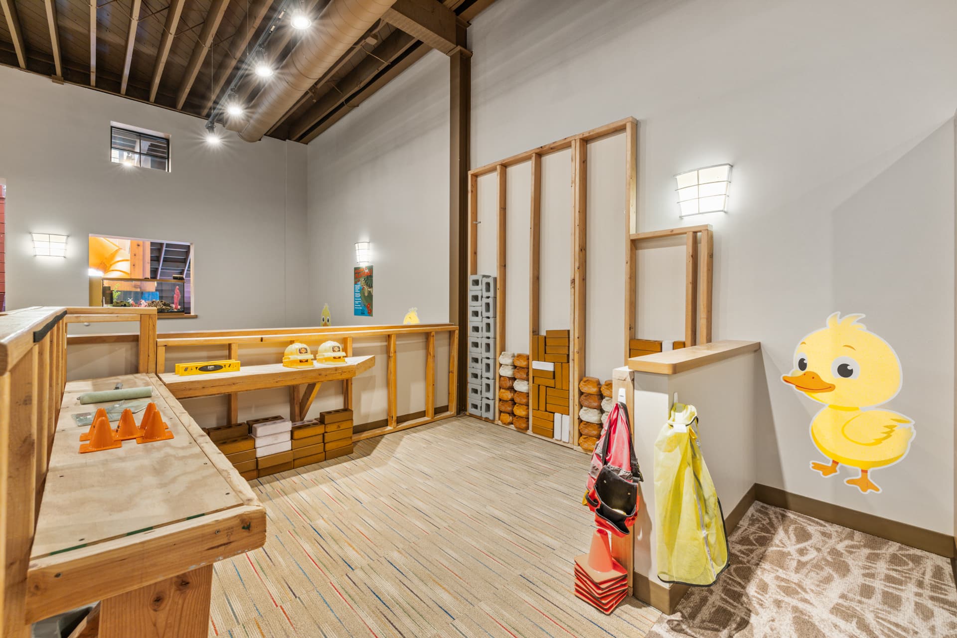 Construction zone with a workbench, hard hats and foam building blocks at Six Little Ducks indoor play space