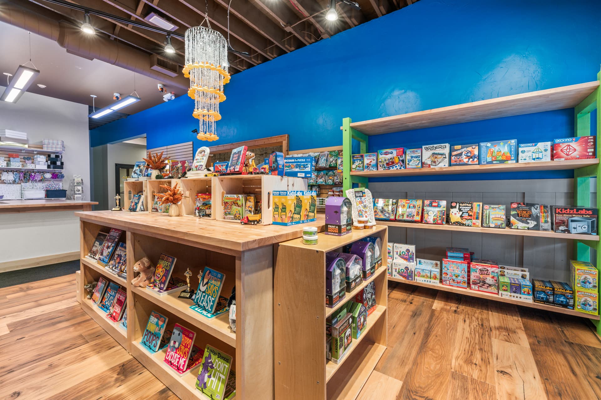 Books, science kits and creative toys displayed on wooden shelves